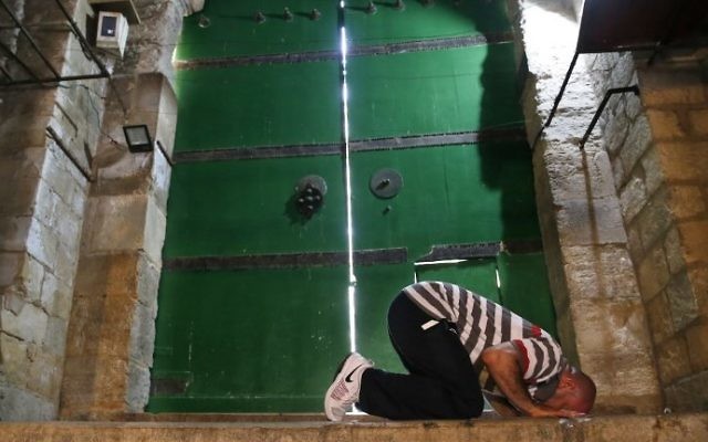 A Muslim man prays in front of a closed gate leading onto the Temple Mount in the Old City of Jerusalem on July 26, 2017. AFP/ AHMAD GHARABLI) A Muslim man prays in front of a closed gate leading onto the Temple Mount in the Old City of Jerusalem on July 26, 2017. AFP/ AHMAD GHARABLI)
