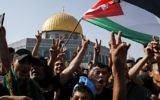 Palestinian Muslims wave a national flag and flash the victory gesture in front of the Dome of the Rock atop the Temple Mount compound in Jerusalem's Old City on July 27, 2017. ( AFP PHOTO / AHMAD GHARABLI)