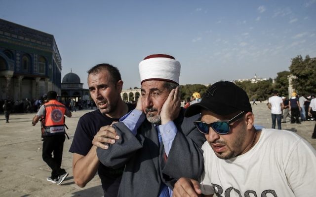 Palestinians escort a Muslim cleric in the Temple Mount compound in the Old City of Jerusalem on July 27, 2017, as clashes erupted with Israeli police at the site after thousands of Muslim worshippers entered to end a boycott of the compound over new Israeli security measures.
(AFP PHOTO / AHMAD GHARABLI) Palestinians escort a Muslim cleric in the Temple Mount compound in the Old City of Jerusalem on July 27, 2017, as clashes erupted with Israeli police at the site after thousands of Muslim worshippers entered to end a boycott of the compound over new Israeli security measures.
(AFP PHOTO / AHMAD GHARABLI)