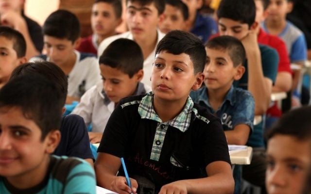 Iraqi boys attend a class at a school in west Mosul on July 27, 2017. (AFP PHOTO / SAFIN HAMED)