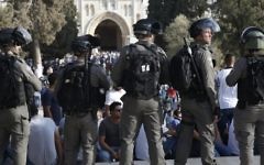Israeli security forces stand before Palestinians on the Temple Mount in Jerusalem on July 27, 2017, with the Al-Aqsa mosque appearing in the background. (AFP PHOTO / AHMAD GHARABLI)