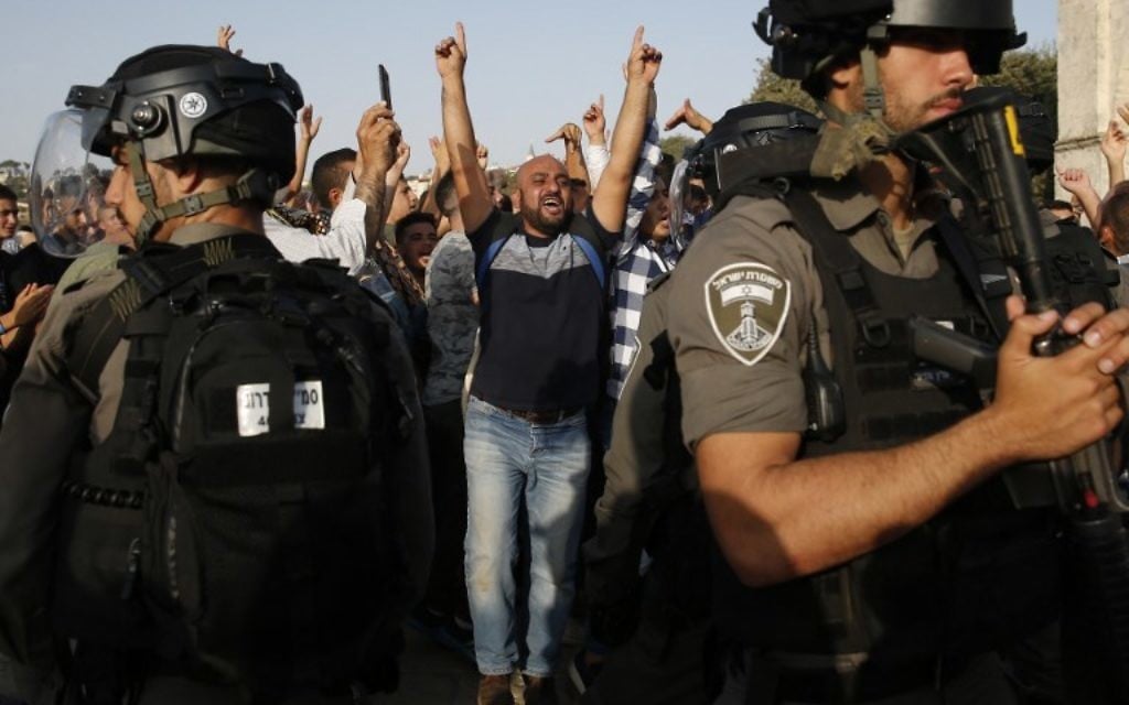 A Palestinian Muslim raises his arms and shouts slogans before Israeli security forces in the Temple Mount compound in the Old City of Jerusalem on July 27, 2017. (AFP Photo/Ahmad Gharabli) A Palestinian Muslim raises his arms and shouts slogans before Israeli security forces in the Temple Mount compound in the Old City of Jerusalem on July 27, 2017. (AFP Photo/Ahmad Gharabli)