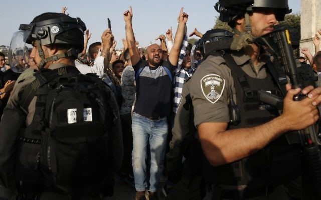 A Palestinian Muslim raises his arms and shouts slogans before Israeli security forces in the Temple Mount compound in the Old City of Jerusalem on July 27, 2017. (AFP Photo/Ahmad Gharabli) A Palestinian Muslim raises his arms and shouts slogans before Israeli security forces in the Temple Mount compound in the Old City of Jerusalem on July 27, 2017. (AFP Photo/Ahmad Gharabli)