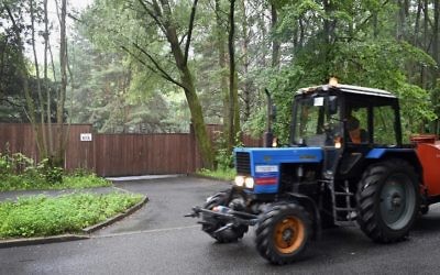 This photo taken on July 13, 2017 shows a municipal worker drives a tractor past the fence around a US diplomatic recreational house in Serebryany Bor park in Moscow. (AFP PHOTO / Alexander NEMENOV)