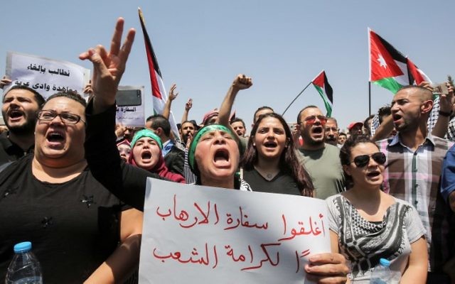 Jordanian protesters wave national flags and chant slogans during a demonstration near the Israeli embassy in the capital Amman on July 28, 2017, calling for the shutting down the of the embassy, expelling the ambassador, and canceling the 1994 peace treaty with Israel. (AFP PHOTO / KHALIL MAZRAAWI) Jordanian protesters wave national flags and chant slogans during a demonstration near the Israeli embassy in the capital Amman on July 28, 2017, calling for the shutting down the of the embassy, expelling the ambassador, and canceling the 1994 peace treaty with Israel. (AFP PHOTO / KHALIL MAZRAAWI)