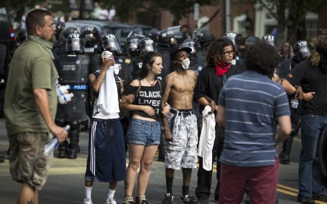 Counter protesters link arms in front of riot police after a rally staged by the Ku Klux Klan on July 8, 2017 in Charlottesville, Virginia. (Chet Strange/Getty Images/AFP)