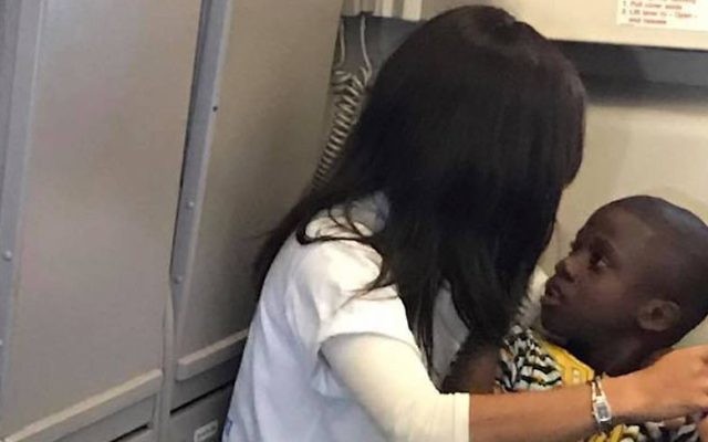 Rochel Groner comforting a child with autism on a flight from Europe to the United States. (Bentzion Groner/Facebook) Rochel Groner comforting a child with autism on a flight from Europe to the United States. (Bentzion Groner/Facebook)