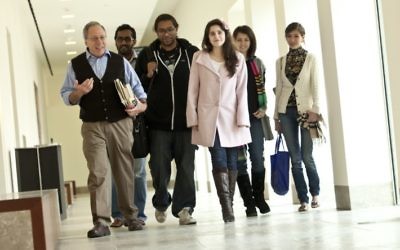 Gary Wasserman, left, strolls through a corridor on the Georgetown campus in Qatar with his students in 2012. (Georgetown University-Qatar)