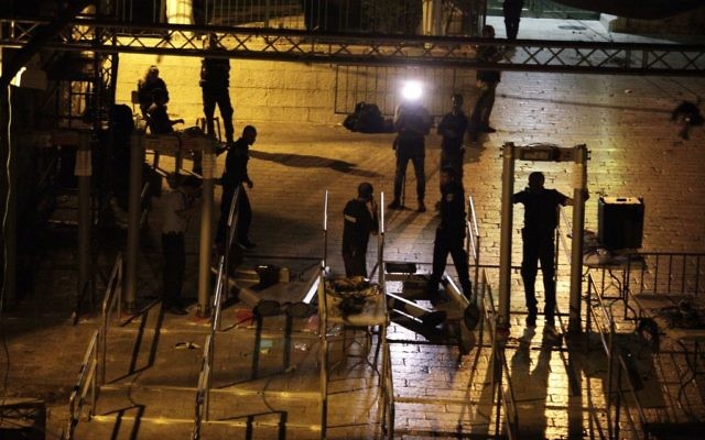 Israeli police officers dismantle metal detectors outside the Temple Mount in Jerusalem's Old City, early Tuesday, July 25, 2017. (AP/Mahmoud Illean)
