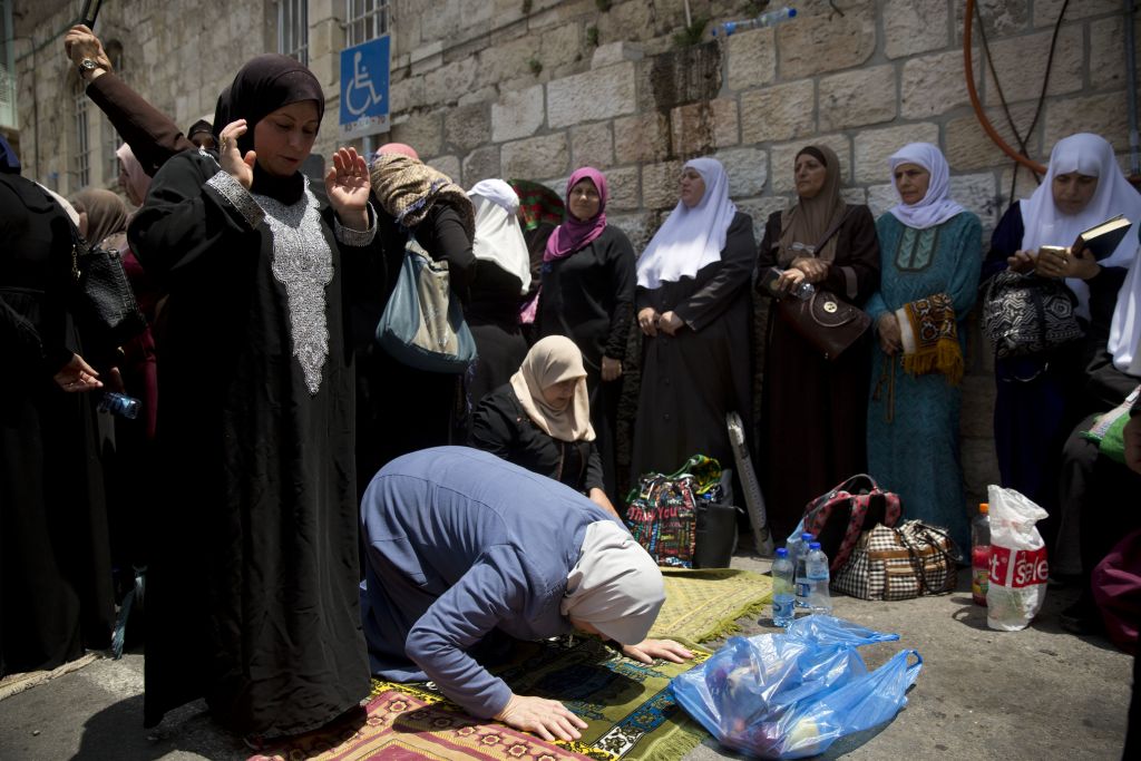 Palestinian women pray near the Temple Mount in Jerusalem's Old City, Tuesday, July 25, 2017. (AP Photo/Oded Balilty) Palestinian women pray near the Temple Mount in Jerusalem's Old City, Tuesday, July 25, 2017. (AP Photo/Oded Balilty)