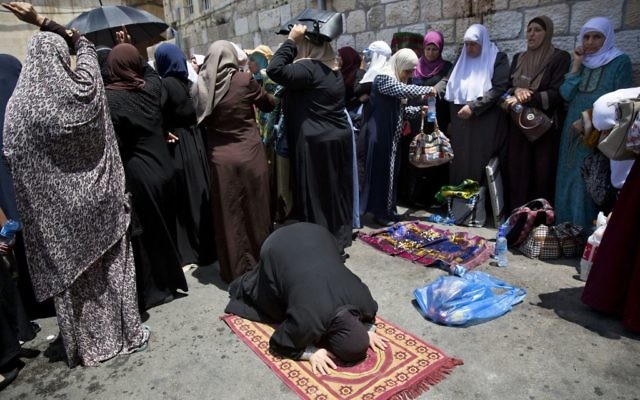 Palestinian women pray near the Lions Gate in Jerusalem's Old City, Tuesday, July 25, 2017. (AP Photo/Oded Balilty) Palestinian women pray near the Lions Gate in Jerusalem's Old City, Tuesday, July 25, 2017. (AP Photo/Oded Balilty)
