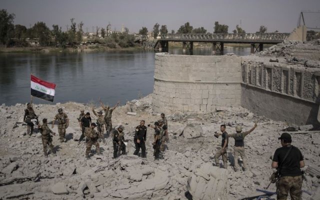 Iraqi Special Forces soldiers celebrate after reaching the bank of the Tigris river as their fight against Islamic State militants continues in parts of the Old City of Mosul, Iraq, Sunday, July 9, 2017. (AP/Felipe Dana)