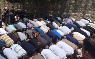 Muslim worshippers stage a prayer protest outside the Temple Mount compound against metal detectors that were set up at the entrance to the holy site after a terror attack two days prior, on July 16, 2017. (Avi Issacharoff/Times of Israel)