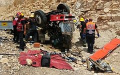 Medics and firefighters pull two men out of a truck that overturned along a highway, north of the city of Eilat, on July 13, 2017. (Magen David Adom)