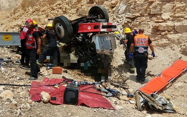 Medics and firefighters pull two men out of a truck that overturned along a highway, north of the city of Eilat, on July 13, 2017. (Magen David Adom) Medics and firefighters pull two men out of a truck that overturned along a highway, north of the city of Eilat, on July 13, 2017. (Magen David Adom)