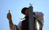 Illustrative: An ultra-Orthodox man erecting an eruv wire, near the Gilo neighborhood in south Jerusalem, on August 14, 2009. (Nati Shohat / FLASH90/File)