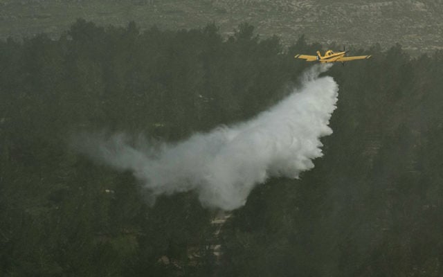 Illustrative: A firefighting plane dumps water on a forest in the Judean Hills during an exercise on March 29, 2012. (Omer Miron/Flash90) Illustrative: A firefighting plane dumps water on a forest in the Judean Hills during an exercise on March 29, 2012. (Omer Miron/Flash90)