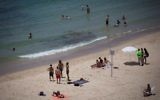 People enjoy the beach in Tel Aviv on a warm summer day on July 4, 2017. (Miriam Alster/Flash90)