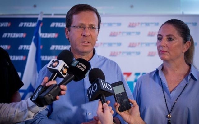 Labor party leader Isaac Herzog, left, arrives with his wife Michal to cast his vote at a polling station in Tel Aviv, July 4, 2017. (Miriam Alster/Flash90) 