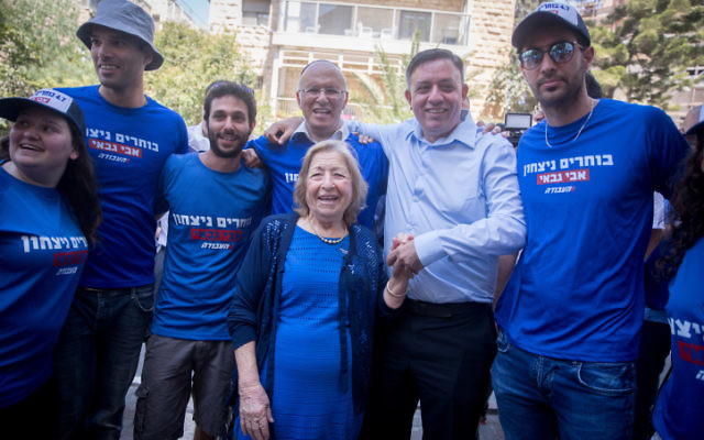 Labour party candidate Avi Gabbay (6l) seen with supporters outside a polling station in Jerusalem on July 4. 2017. (Yonatan Sindel/Flash90) Labour party candidate Avi Gabbay (6l) seen with supporters outside a polling station in Jerusalem on July 4. 2017. (Yonatan Sindel/Flash90)