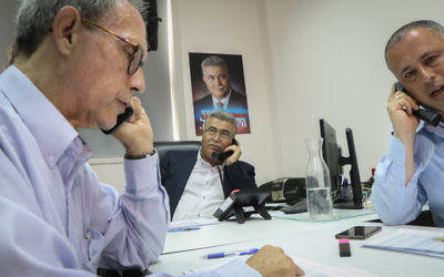 Labor party leadership contender Amir Peretz (C), with party members Hilik Bar (R) and Nachman Shai (L) phoning potential voters ahead of the second round of the Labor party primaries in Tel Aviv on July 9, 2017. (Flash90)