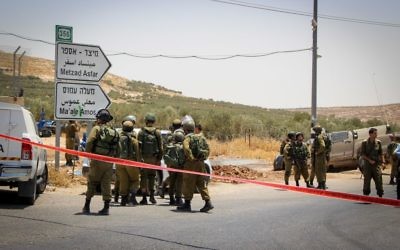 Illustrative: Soldiers at the scene of a car-ramming attack on a highway in the central West Bank on July 10, 2017. (Gershon Elinson/Flash90)
