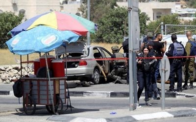 Israeli security forces gather at the scene of a car-ramming attack at the entrance to the West Bank village of Beit Anoun on July 18, 2017. ( Wisam Hashlamoun/Flash90)