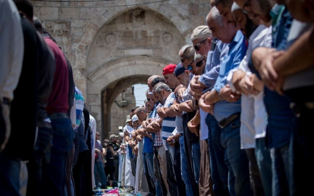 Muslim worshipers perform noon prayers at the Lions Gate, outside the Temple Mount, in Jerusalem's Old City on July 19, 2017. (Yonatan Sindel/Flash90)
