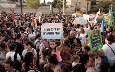 A girl carries a sign reading 'I have two mothers and I'm happy' as thousands protest in support of the right of LGBT couples to adopt children in Tel Aviv on July 20, 2017. (Tomer Neuberg/FLASH90)
