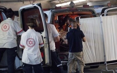 Medics wheel a woman who was injured during a stabbing attack in the West Bank settlement of Halamish into the emergency room of the Shaare Zedek Medical Center in Jerusalem on July 21, 2017. (Yonatan Sindel/Flash90) 