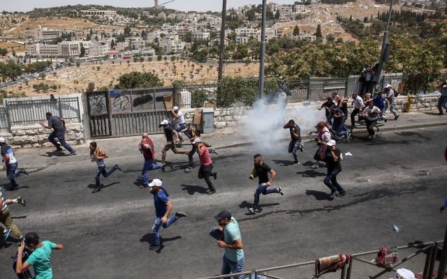 Palestinians run as Israeli police fire tear gas after Friday prayers in the East Jerusalem neighborhood of Wadi al-Joz, July 28, 2017 (Miriam Alster/Flash90) Palestinians run as Israeli police fire tear gas after Friday prayers in the East Jerusalem neighborhood of Wadi al-Joz, July 28, 2017 (Miriam Alster/Flash90)