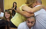 Former IDF Sgt. Elor Azaria is squeezed between his father, Charlie (R), and Likud MK Nava Boker, as they hug in the courtroom at the Kirya military base in Tel Aviv, on July 30, 2017. (Avshalom Sasoni/Flash90)