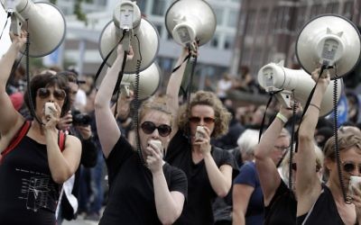 Women hold up megaphones during a protest against the G-20 summit in Hamburg, northern Germany, Saturday, July 8, 2017. (AP Photo/Matthias Schrader)