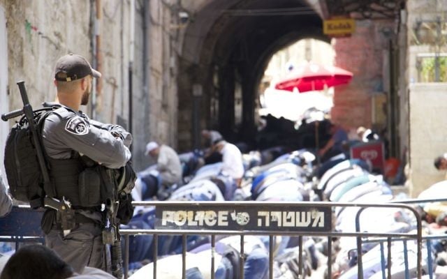 Muslim worshipers pray just outside the Lions Gate in Jerusalem on July 21, 2017. (Dov Lieber/Times of Israel)