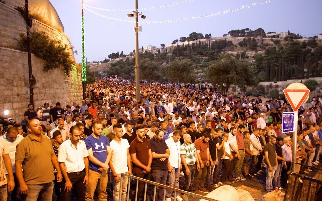 Thousands of Muslim worshipers participate in evening prayers outside the Lions Gate in the Old City of Jerusalem, refusing to enter the Temple Mount enclosure to reach the Al-Aqsa Mosque inside, July 25, 2017. (Dov Lieber /Times of Israel)