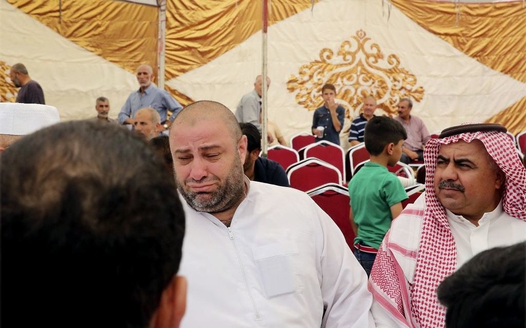 Zakaria al-Jawadah, center left, the father of Mohammed Mohammed al-Jawawdeh, a 17-year-old Jordanian, who was killed on Sunday evening by an Israeli security guard who said he was attacked by him with a screwdriver, cries at a funeral tent in Amman, Jordan, Monday, July 24, 2017.  (AP Photo/Reem Saad)