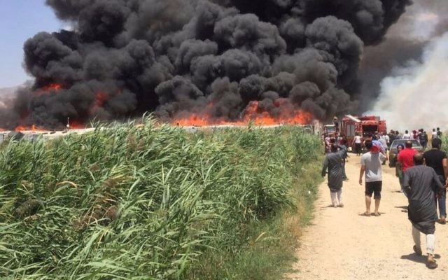 This photo provided by the Qab Elias Emergency Services, shows smoke billowing from a Syrian refugee camp in Qab Elias, a village in the Bekaa Valley, Lebanon in Qab Elias, Lebanon, Sunday, July 2, 2017. (Qab Elias Emergency Services via AP)