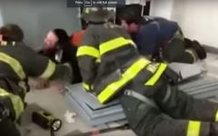 Screen capture from video shows firefighters rescuing an ultra-Orthodox man after he hid inside a safe that toppled on top of him in a yeshiva in Flatbush, New York, July 10, 2017. (YouTube/VINnews)