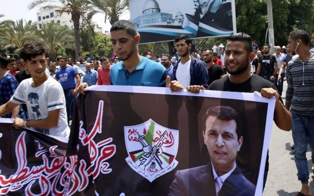 Hundreds of supporters of exiled former Gaza strongman Mohammed Dahlan carry a banner with his picture during a protest against metal detectors Israel erected at the Al-Aqsa Mosque compound in Jerusalem, in Gaza City, Thursday, July 20, 2017. (AP/Adel Hana) Hundreds of supporters of exiled former Gaza strongman Mohammed Dahlan carry a banner with his picture during a protest against metal detectors Israel erected at the Al-Aqsa Mosque compound in Jerusalem, in Gaza City, Thursday, July 20, 2017. (AP/Adel Hana)