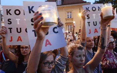 Anti-government protesters raise candles and placards reading 'Constitution,' as they gather in front of the Supreme Court in Warsaw, Poland, Saturday, July 22, 2017 (AP Photo/Alik Keplicz)
