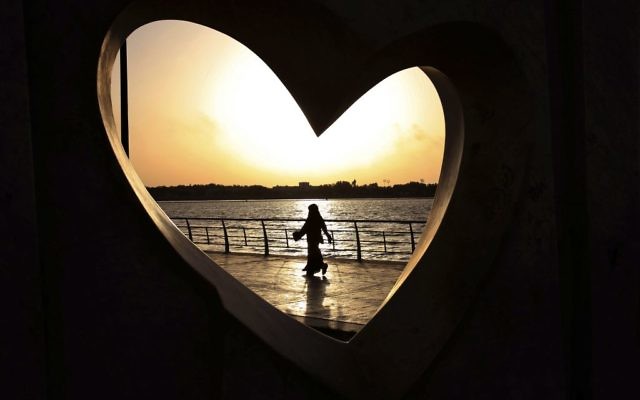 In this May 11, 2014 photo, a Saudi woman is seen through a heart-shaped statue walks along an inlet of the Red Sea in Jiddah, Saudi Arabia. (AP Photo/Hasan Jamali) In this May 11, 2014 photo, a Saudi woman is seen through a heart-shaped statue walks along an inlet of the Red Sea in Jiddah, Saudi Arabia. (AP Photo/Hasan Jamali)
