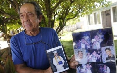 In this Monday, July 10, 2017 photo, Clifford Kang, father of soldier Ikaika E. Kang, poses with photo of his son in Kailua, Hawaii. (Bruce Asato/The Star-Advertiser via AP)