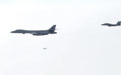 In this photo provided by South Korea Defense Ministry, A U.S. Air Force B-1B Lancer bomber, left, drops a bomb over the Korean Peninsula, South Korea Saturday, July 8, 2017.  (South Korea Defense Ministry via AP)