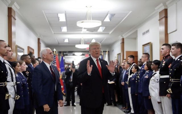 President Donald Trump stops to answer a reporter's question after greeting military personnel during a visit to the Pentagon, Thursday, July 20, 2017. Watching is Vice President Mike Pence. (AP Photo/Pablo Martinez Monsivais)