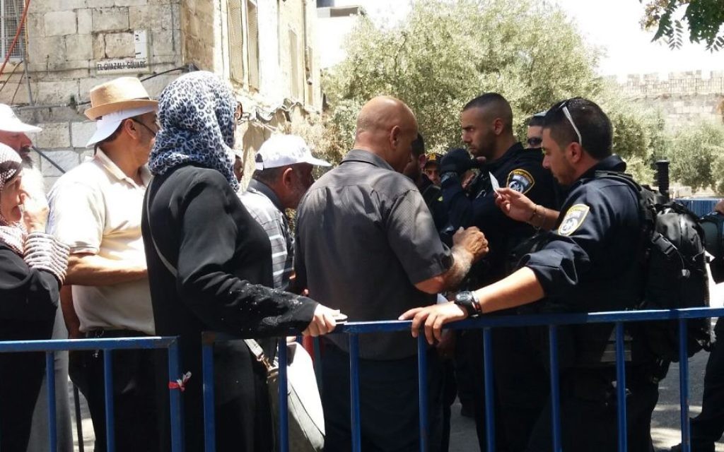 Police check the ID cards of Muslim worshipers at the Gate of the Tribes in Jerusalem's Old City on July 27, 2017. (Dov Lieber/Times of Israel)