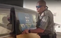 A Border Police officer opens the door of a van alleged to be transporting Palestinians illegally in Israel on July 2, 2017. (Screen capture: YouTube)