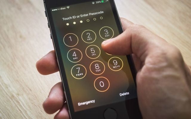 Apple iPhone5 showing its screen with numpad for entering the passcode. (Watschiwit/iStock)