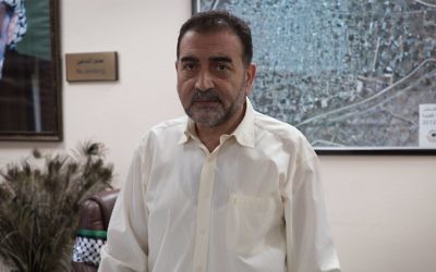 Mayor of Qalqiliya Hashim al-Masri stands in his office. (Luke Tress / Times of Israel)