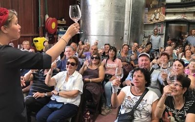 Vered Saadon toasting with an Israeli tour group at her Tura Winery in the West Bank settlement of Rahelim, June 21, 2017. (Andrew Tobin/JTA)