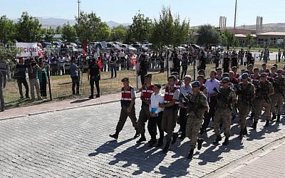 Turkish paramilitary officers escort defendants, among them Kemal Batmaz (first row, C) and Akin Ozturk (second row, C),  as they arrive for their trial at Sincan Penal Institution at the 4th Heavy Penal Court near Ankara on August 1, 2017.  (AFP Photo/Adem Altan)